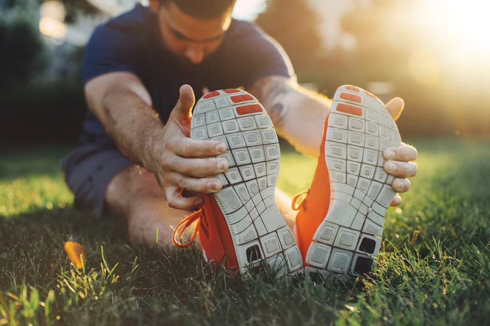 Attractive,Young,Man,Stretching,In,The,Park,Before,Running,At