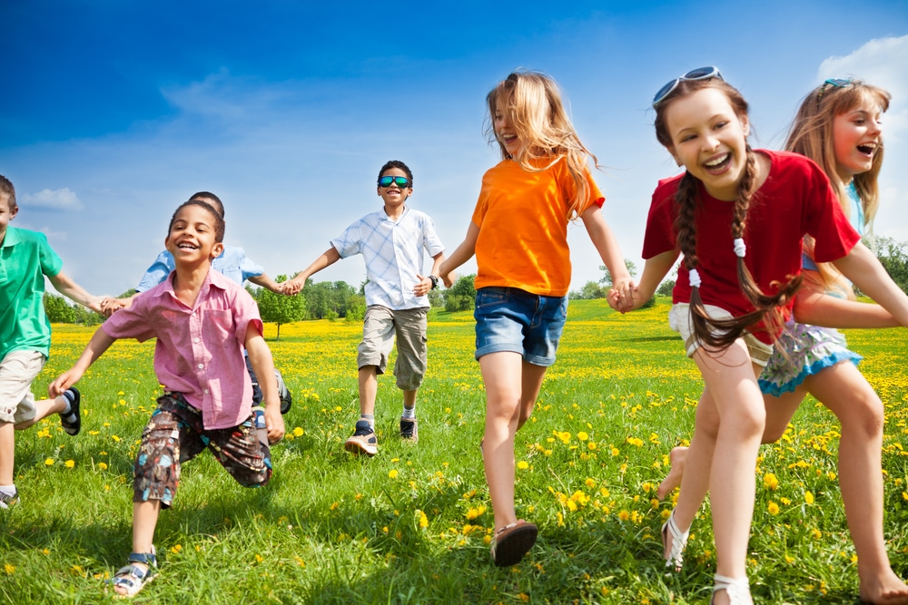 Large,Group,Of,Children,Running,In,The,Dandelion,Spring,Field