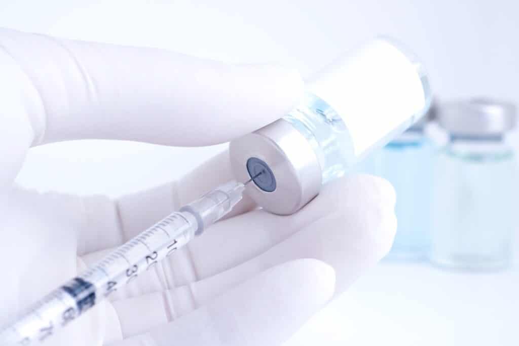 Hand of doctor holding syringe and medicine bottle. Preparing for injection