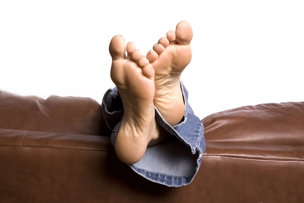 A,Woman's,Feet,Relaxing,And,Hanging,Over,The,Back,Of